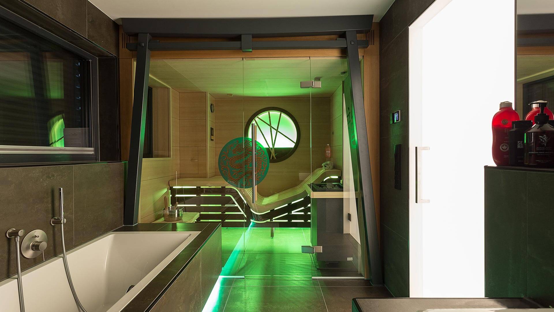 Built-in sauna cabin with torii gate element in a dark tiled wellness room